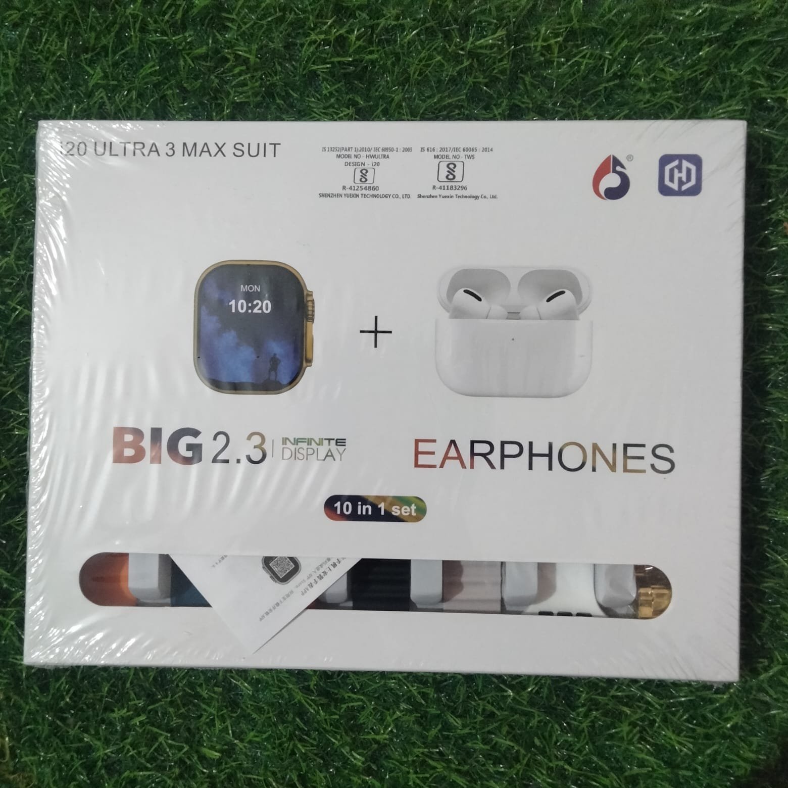 20 Ultra 3 Max Suit 10-in-1 mega tech combo box showing a 2.3 inch infinite display smartwatch and white wireless TWS earphones over a green grass surface